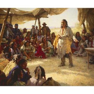 Native American Man Standing in Middle of Crowd, Gesturing towards a table